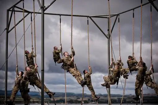 Royal Marines climbing ropes on an assault course