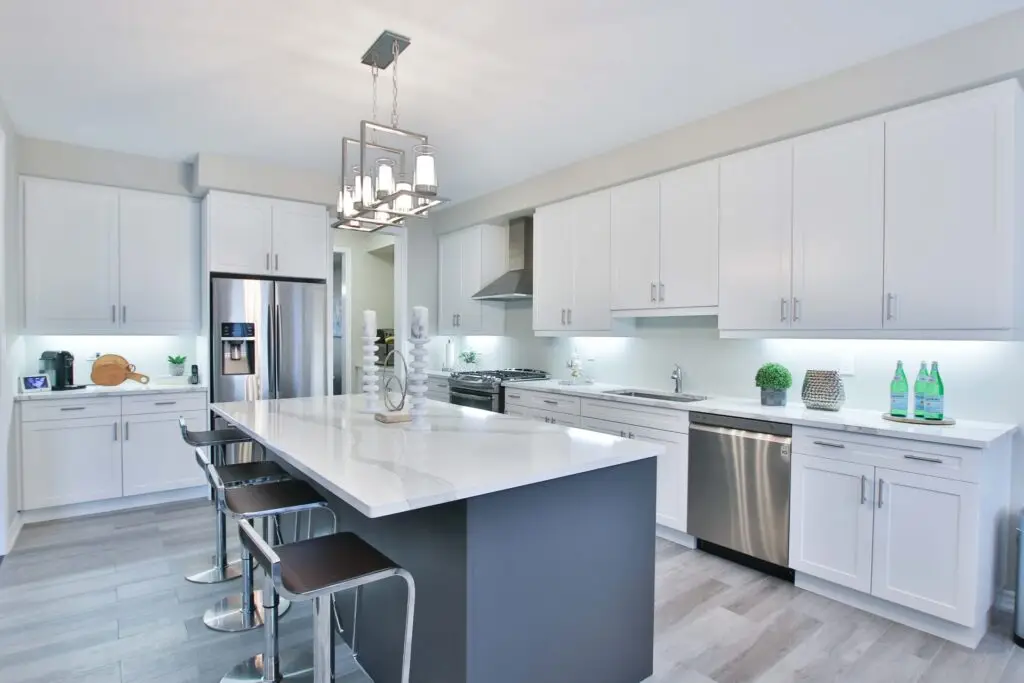 Modern kitchen with an island, white cabinets and marble work surfaces